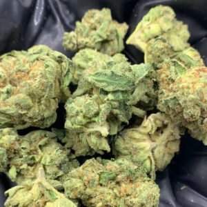 Sweet Melon THCa Flower buds with light green hues, orange pistils, and frosty trichomes.